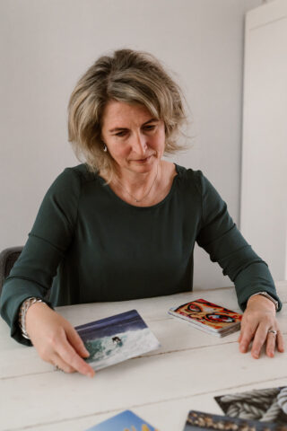 Bianca van Walbeek aan een witte tafel met beeldkaarten